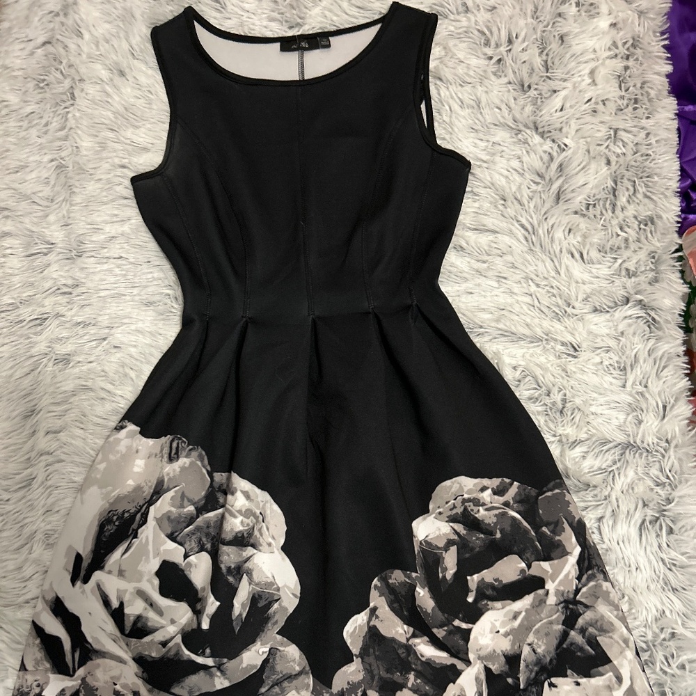 Black form fitting dress that flares out to make any occasion a perfect choice .